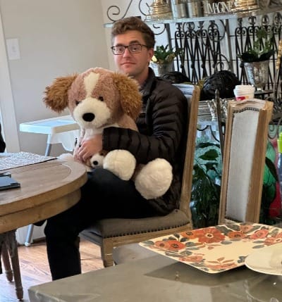 A (not) very professional headshot of me holding on to a giant stuffed puppy dog.